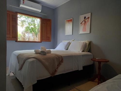 a bedroom with a bed with a teddy bear on it at Recanto Verde - Praia de Santo Antônio in Diogo