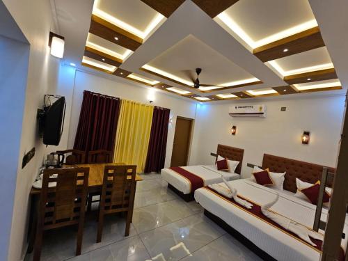 Habitación con 2 camas, mesa y TV. en MARINA SUITES AIRPORT HOTEL, en Kochi