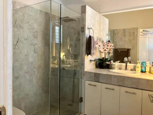 a bathroom with a glass shower and a sink at Villa Flamingo Golf Ixtapa in Ixtapa