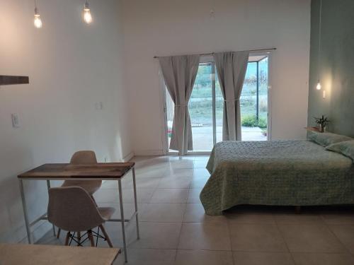 1 dormitorio con cama, mesa, mesa y sillas en Casa Tierra Verde Oliva en Luján de Cuyo
