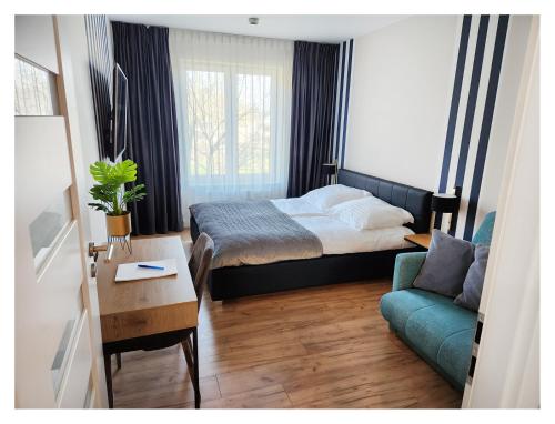 niewielka sypialnia z łóżkiem i kanapą w obiekcie Rest Luxury Apartments w Kołobrzegu