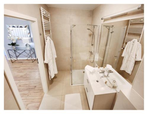 biała łazienka z prysznicem i umywalką w obiekcie Rest Luxury Apartments w Kołobrzegu