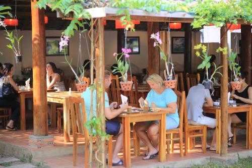 un gruppo di persone sedute ai tavoli di un ristorante di La Mer Resort, Phú Quốc a Phu Quoc