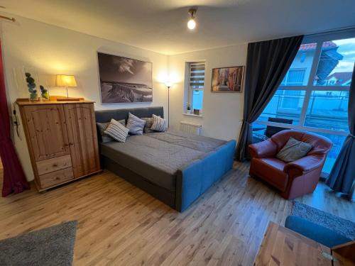a bedroom with a bed and a chair and a window at Ferienwohnung am Yachthafen Waren Müritz in Waren