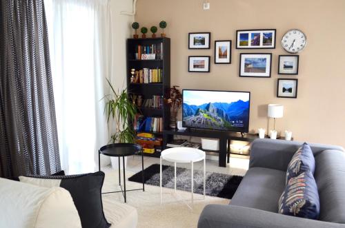 a living room with a couch and a tv at Downtown apartment in Kamena Vourla