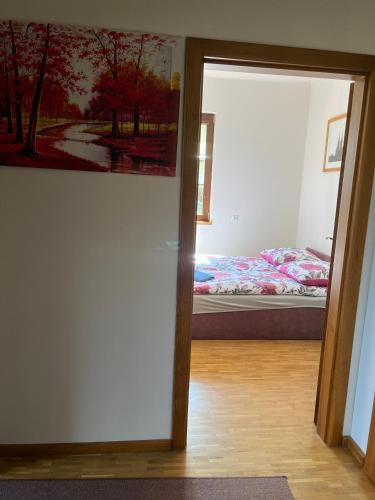 a bedroom with a bed and a painting on the wall at Spalskie Pokoje Gościnne in Spała