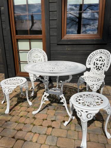 a white table and four chairs and a table and chairs at Spalskie Pokoje Gościnne in Spała