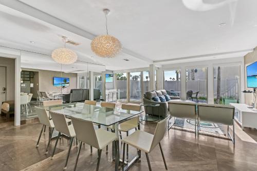 a dining room with a glass table and chairs at Upscale Modern Villa Private w Terrace in Bahia Mar Beachfront Resort, Heated Pool! in South Padre Island