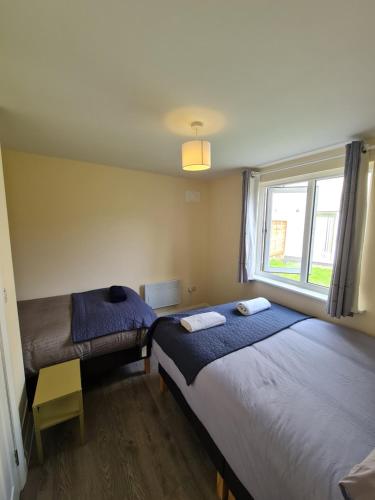 a bedroom with two beds and a window at Cosy Garden Studio near Dublin Airport in Dublin