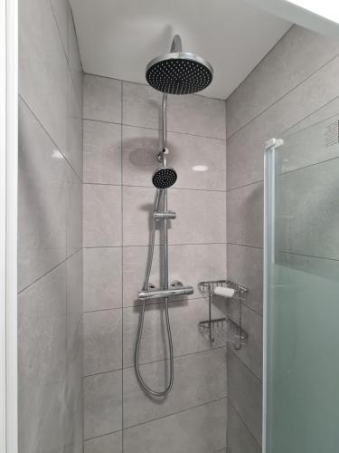 La salle de bains est pourvue d'une douche avec un pommeau de douche. dans l'établissement Cosy Garden Studio near Dublin Airport, à Dublin