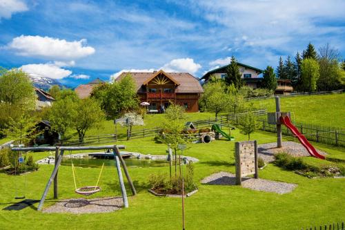 a playground in front of a building with a house at Familien-Appartements Örglwirt's Gut in Mariapfarr