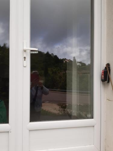 a person taking a picture of a window at Gîte les coquelicots in Morbier