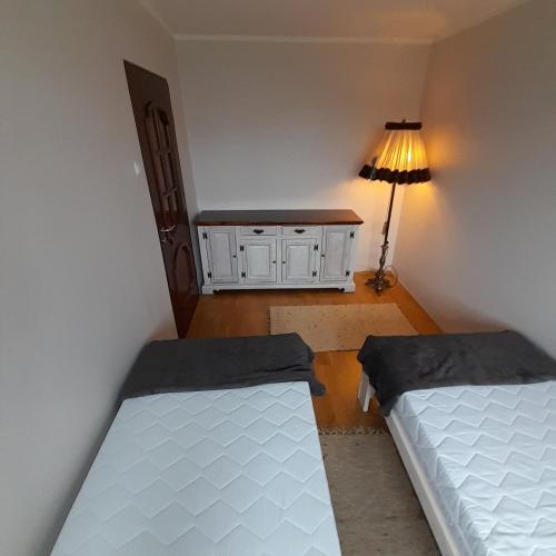 ein kleines Zimmer mit 2 Betten und einer Lampe in der Unterkunft Mieszkanie z balkonem in Głuszyca