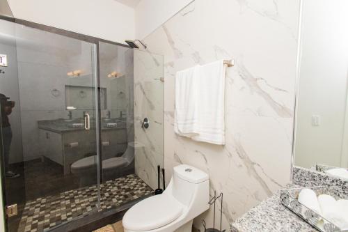 a bathroom with a shower and a toilet and a sink at Residence 4 in Puerto Peñasco