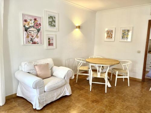 Elena Playa Sol في الكوذيا: غرفة معيشة مع كرسي أبيض وطاولة
