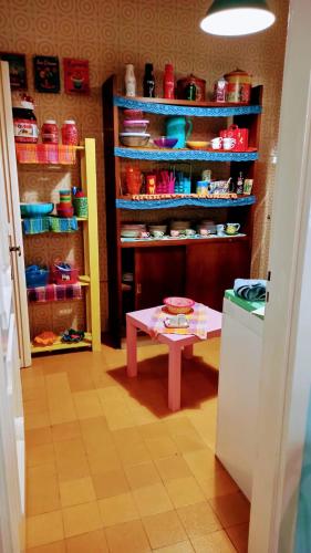 a room with a table and shelves with dishes at The Secret Garden Maratea - Casa di Sery in Maratea