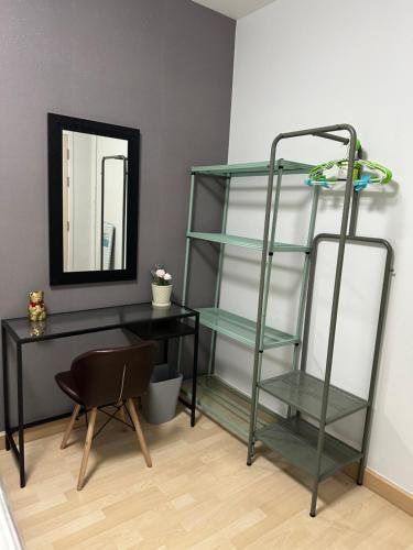 a room with a desk and a shelf and a mirror at S Villa @Impact Muangthongthani in Pak Kret