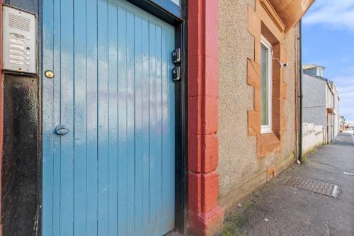 una puerta azul en el lateral de un edificio en Bella Casa two, en Largs