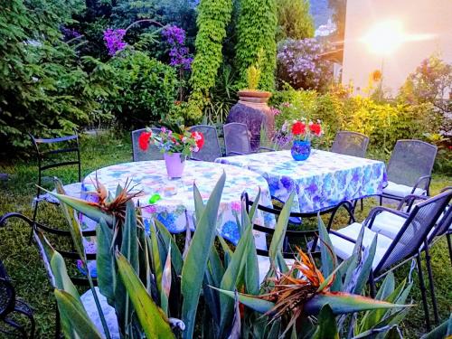 a table and chairs with flowers on it in a garden at The Secret Garden Maratea - Casa di Sery in Maratea