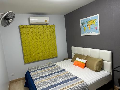 a small bedroom with a bed with a yellow wall at S Villa @Impact Muangthongthani in Pak Kret