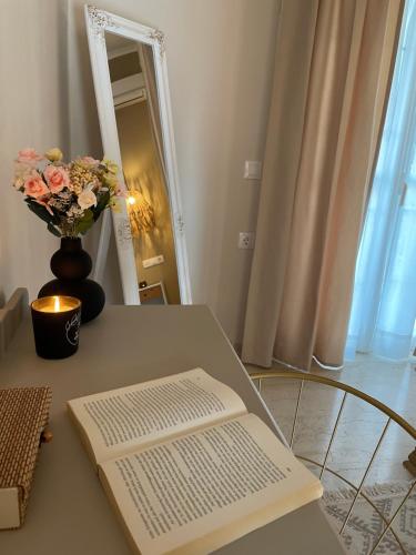 a table with a book and a vase of flowers on it at Villa Sandra in Litherés