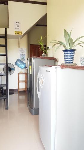 a kitchen with a white refrigerator and a table at JZA Transient House in Cagayan de Oro