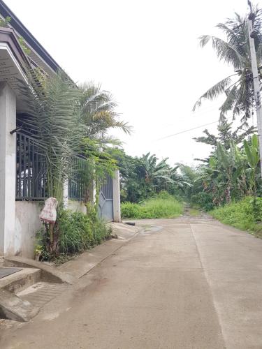 an empty street next to a building with palm trees at JZA Transient House in Cagayan de Oro