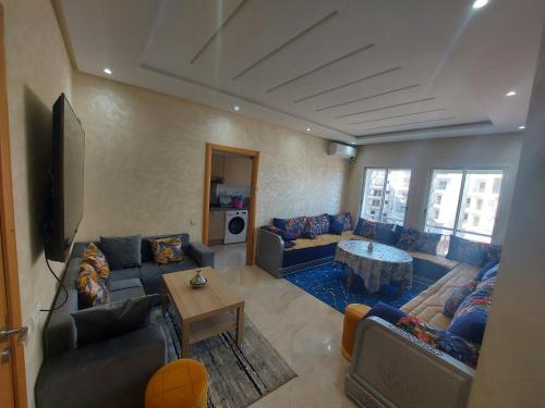 ブズニカにあるLux Apartment In Bouznika With Poolのソファとテーブル付きの広いリビングルーム