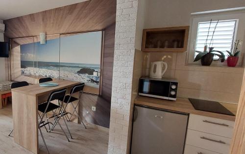 una cucina con bancone e tavolo con forno a microonde di Apartman Saric K&M a Baška Voda