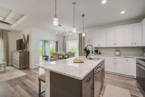 a large kitchen with white cabinets and a large island at South West Florida Family Home, 3 Bedroom,2 Bathroom, King bed suite, Close to Beaches, Parks, Fishing, Golfing, Kayaking in Rotunda-West