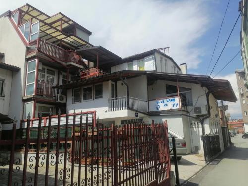 a white building with a fence in front of it at Blue Lake hostel in Ohrid