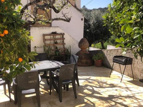 un patio con mesa, sillas y naranjas en Gîte Manubelle, 