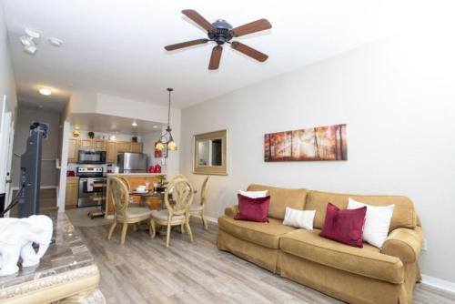 a living room with a couch and a ceiling fan at Charming 3-Bedroom Villa in Gated Community - Your Perfect Getaway! in Kissimmee