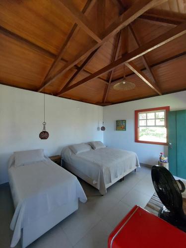 a bedroom with two beds and a wooden ceiling at Chalés Vila das Cachoeiras in Diamantina
