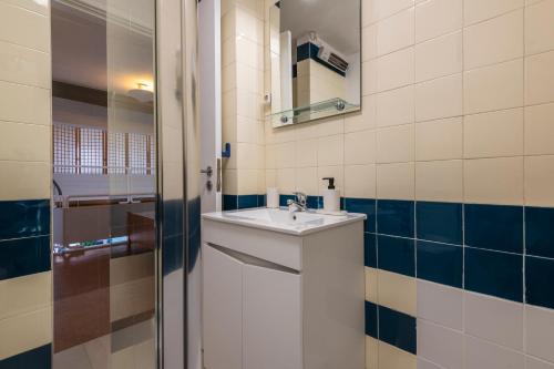 een badkamer met een wastafel en een spiegel bij Casa do Sol Residence in Albufeira