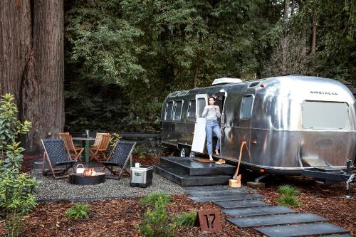 a woman standing in the doorway of a trailer at AutoCamp Yosemite in Midpines