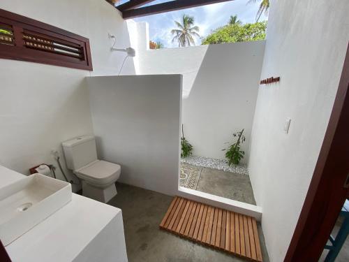 a white bathroom with a toilet and a window at Os Navegantes -Casa Vento in Icaraí