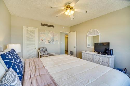um quarto com uma cama e uma ventoinha de tecto em Oceanview Condo on Satellite Beach! em Satellite Beach