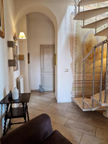 a living room with a spiral staircase and a table at “Attico Garibaldi” nel cuore della Toscana in Sinalunga