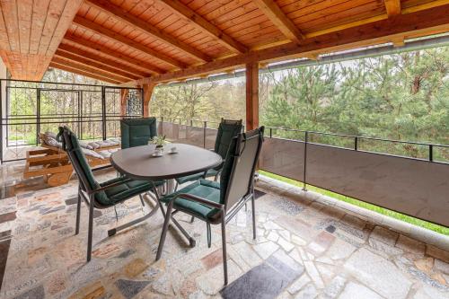 ein Esszimmer mit einem Tisch und Stühlen auf dem Balkon in der Unterkunft Goričko Relax House in Kuzma