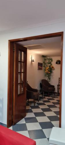 a living room with a door and a checkered floor at Casa O Arco Alojamento Local in Marvão