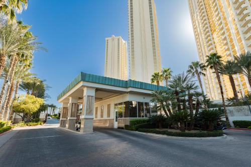 a building with palm trees and tall buildings at MGM Signature, Centrally Located, Strip Views NO RESORT FEE in Las Vegas