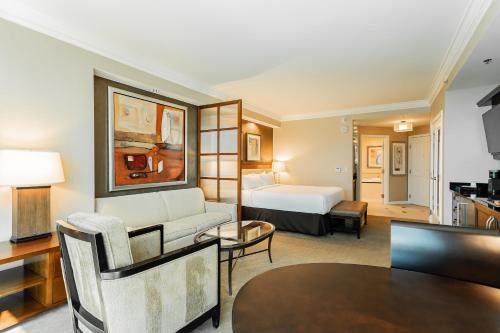 a hotel room with a bed and a living room at MGM Signature, Centrally Located, Strip Views NO RESORT FEE in Las Vegas