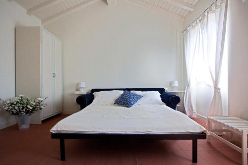 a bedroom with a bed with a blue headboard and a window at Casali Romei in Sarzana