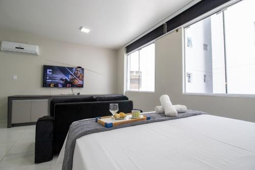 a bedroom with a bed and a couch and a tv at POS25B - Climatizado, TV Smart, Garagem, Wi-Fi in Balneário Camboriú