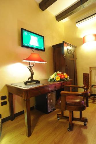a room with a desk with a tv on the wall at B&B Muro Torto Cairoli - Struttura sanificata giornalmente con prodotti specifici conformi al Decalogo del Ministero Salute - Personale sottoposto a test sierologico periodicamente in Foggia