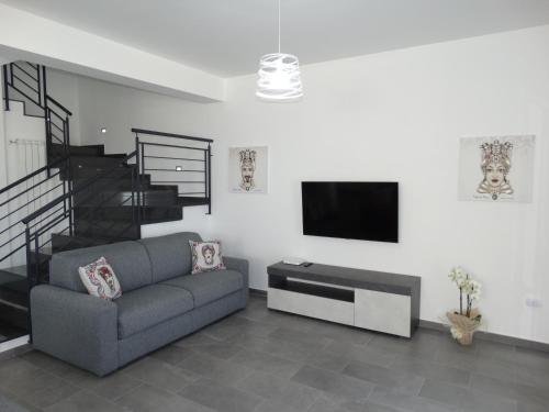 ein Wohnzimmer mit einem Sofa und einem Flachbild-TV in der Unterkunft Villa Milicia in Altavilla Milicia