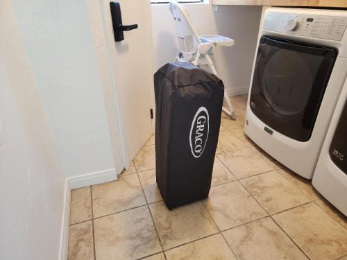 a black suitcase sitting next to a tv in a kitchen at Hot Tub-EV-AC-Kid Friendly-Arcade Game-Lake Access in Lake Arrowhead
