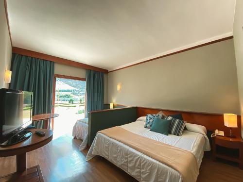 a hotel room with a bed and a flat screen tv at Villa Itaipava Resort & Conventions in Itaipava