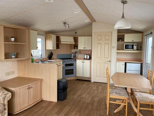 a small kitchen with a table and a dining room at MV194 Golden Palm Resort in Chapel Saint Leonards